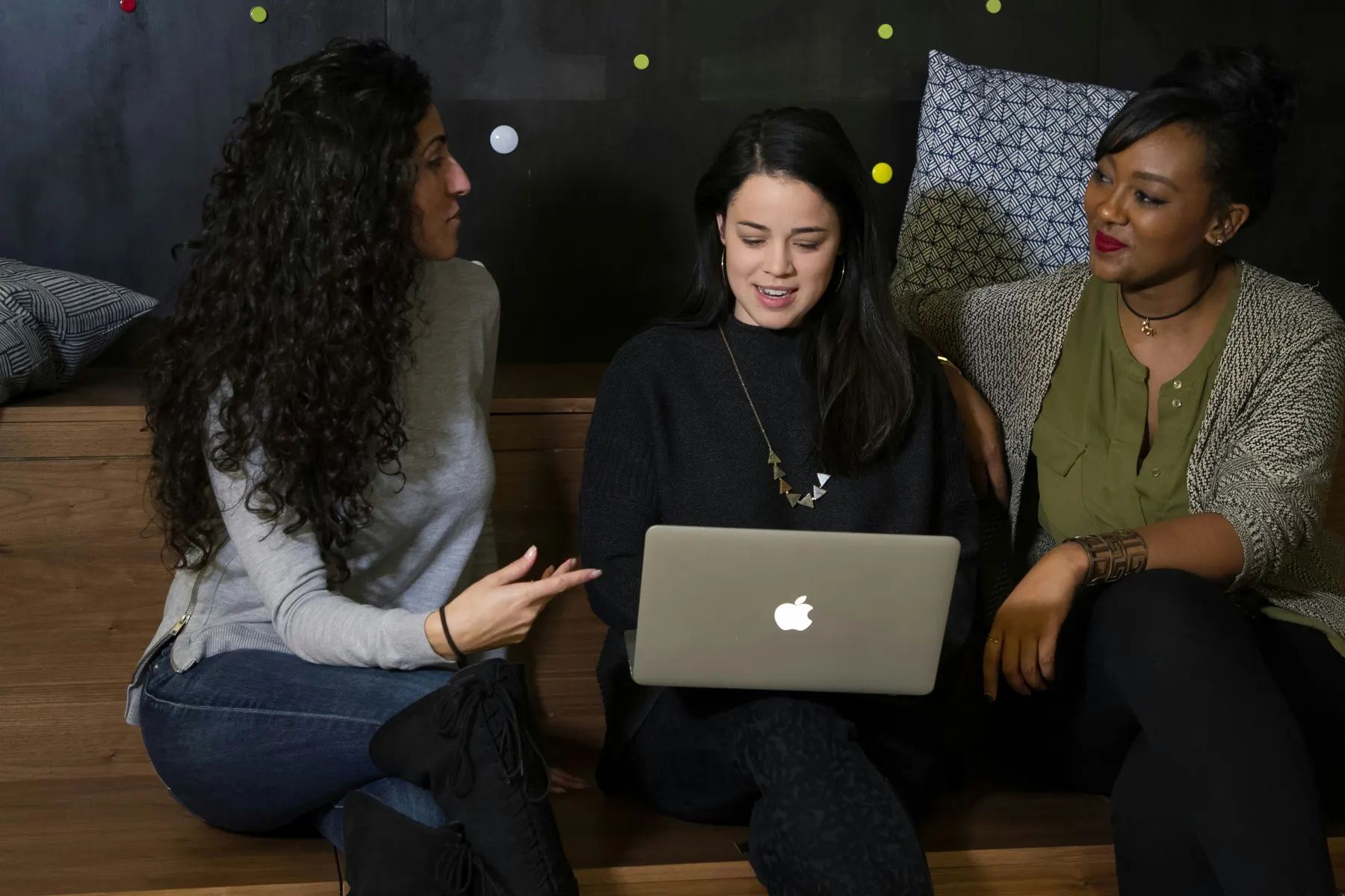 Three reviewers looking at a laptop together in a focused discussion.